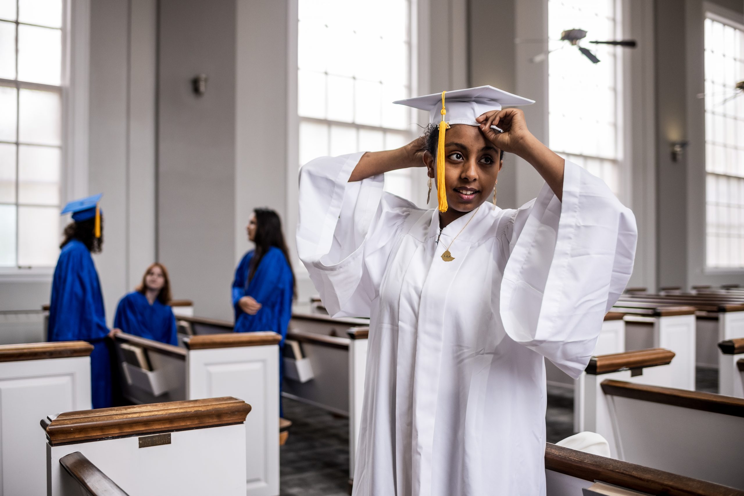 Students wearing white and blue graduation regalia 