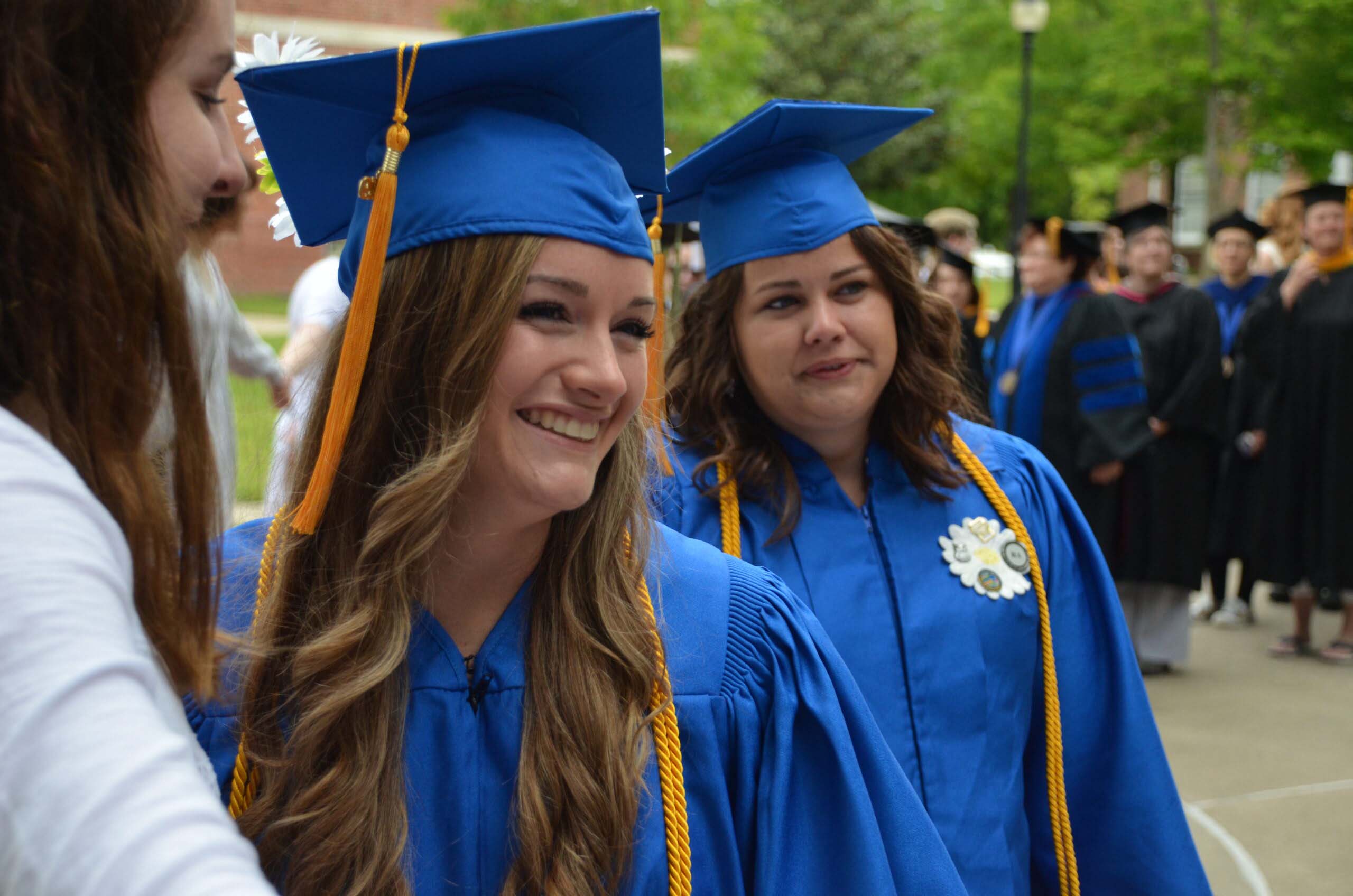 Cottey College graduates smiling in blue regalia