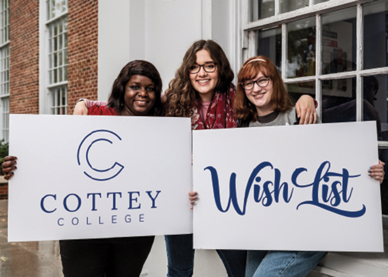 College students holding Cottey signs in front of historical library