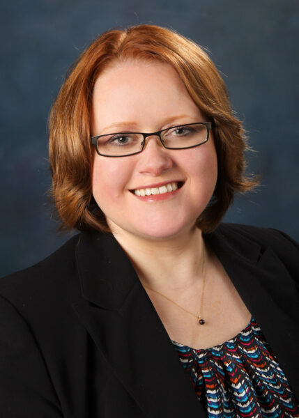 Smiling woman with red hair and glasses, Cottey College