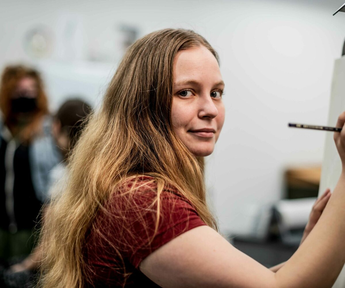 Cottey College student drawing on a sketchpad in art studio