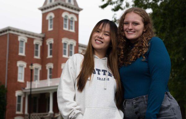 Two Cottey College students smiling in front of Main Hall.