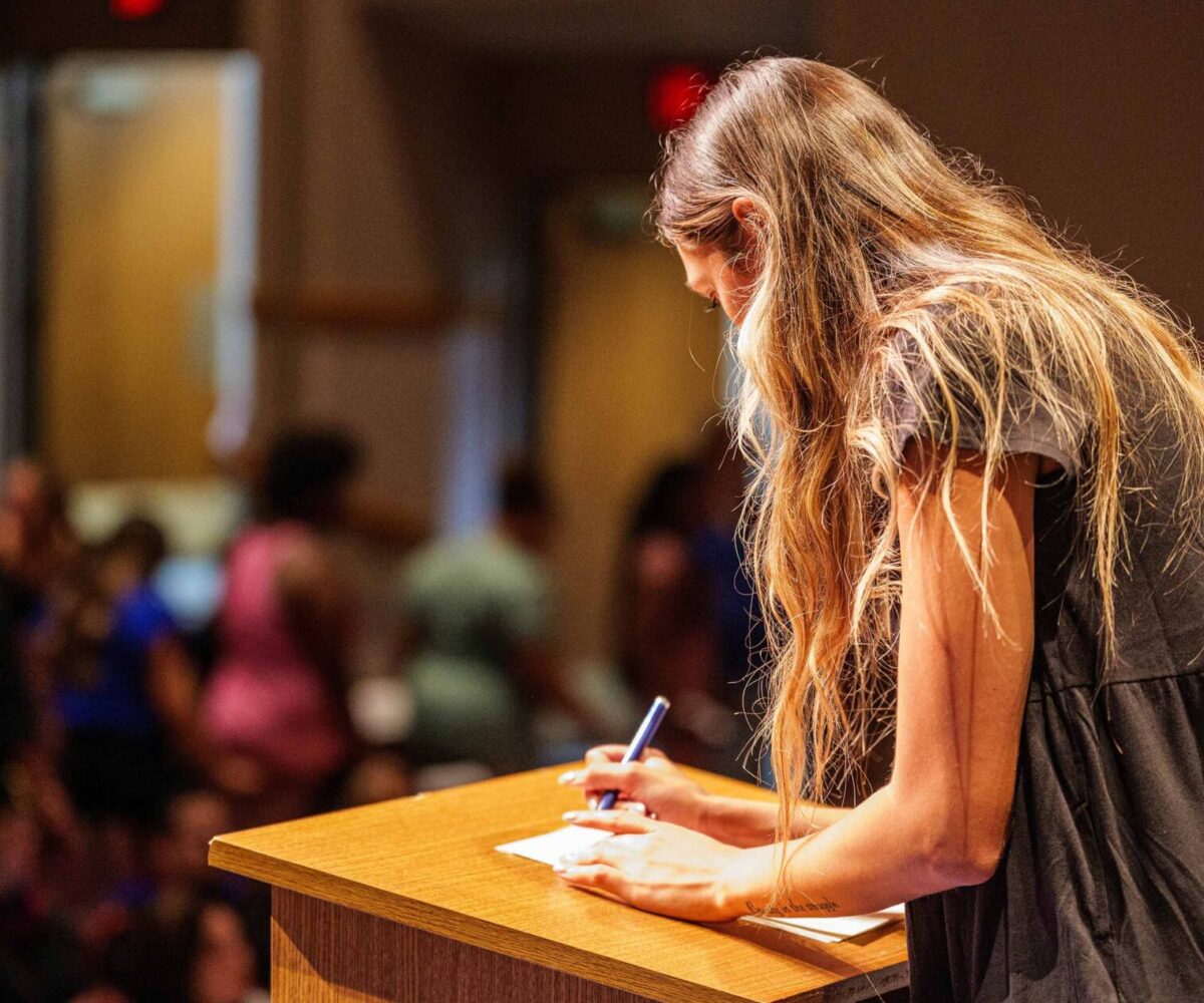 A Cottey College student signing the 'Cottey Book' as part of the convocation tradition.