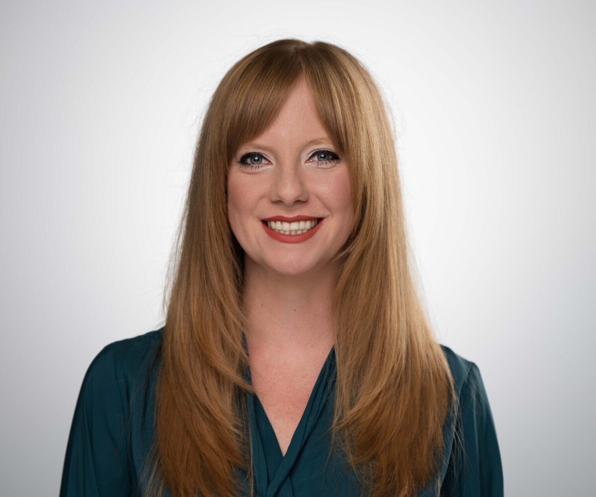 Female Cottey College professor with shoulder-length sandy-blond hair and a teal business shirt.