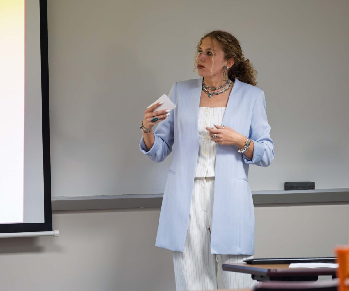 Student in blue and white suit giving a presentation at Cottey College.