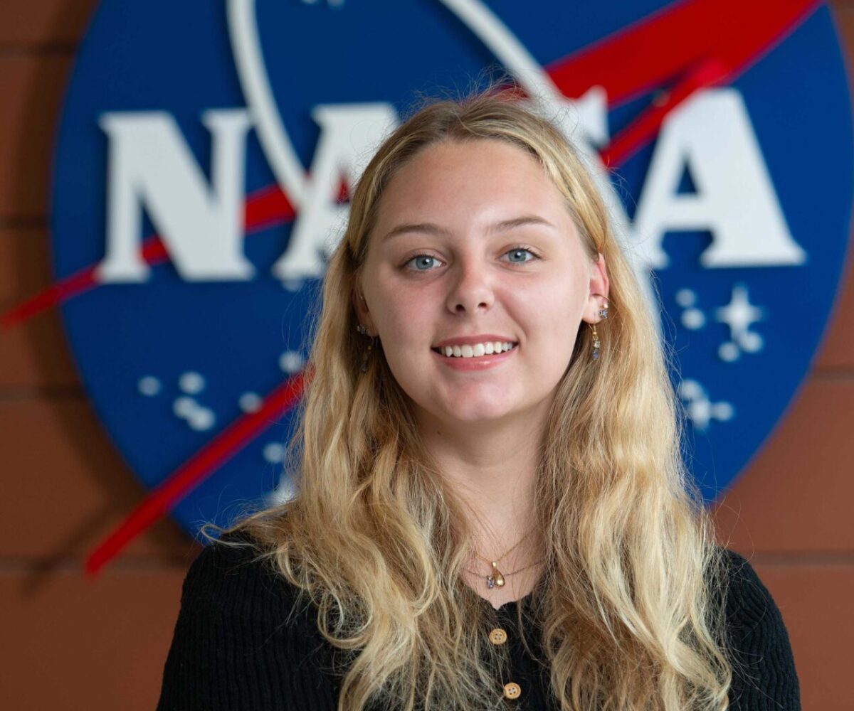 Cottey student in black shirt standing in fron of NASA sign at the Langley Falls Research Center.