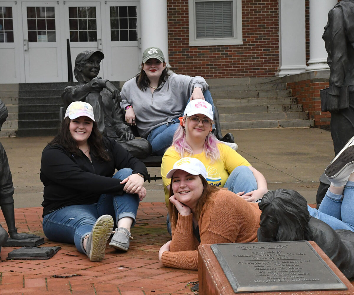 Cottey students and employeed lounging in the statue garden in front of Hinkhouse.