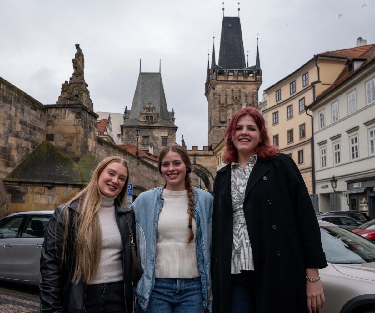 Three Cottey College students standing in front of European architecture.